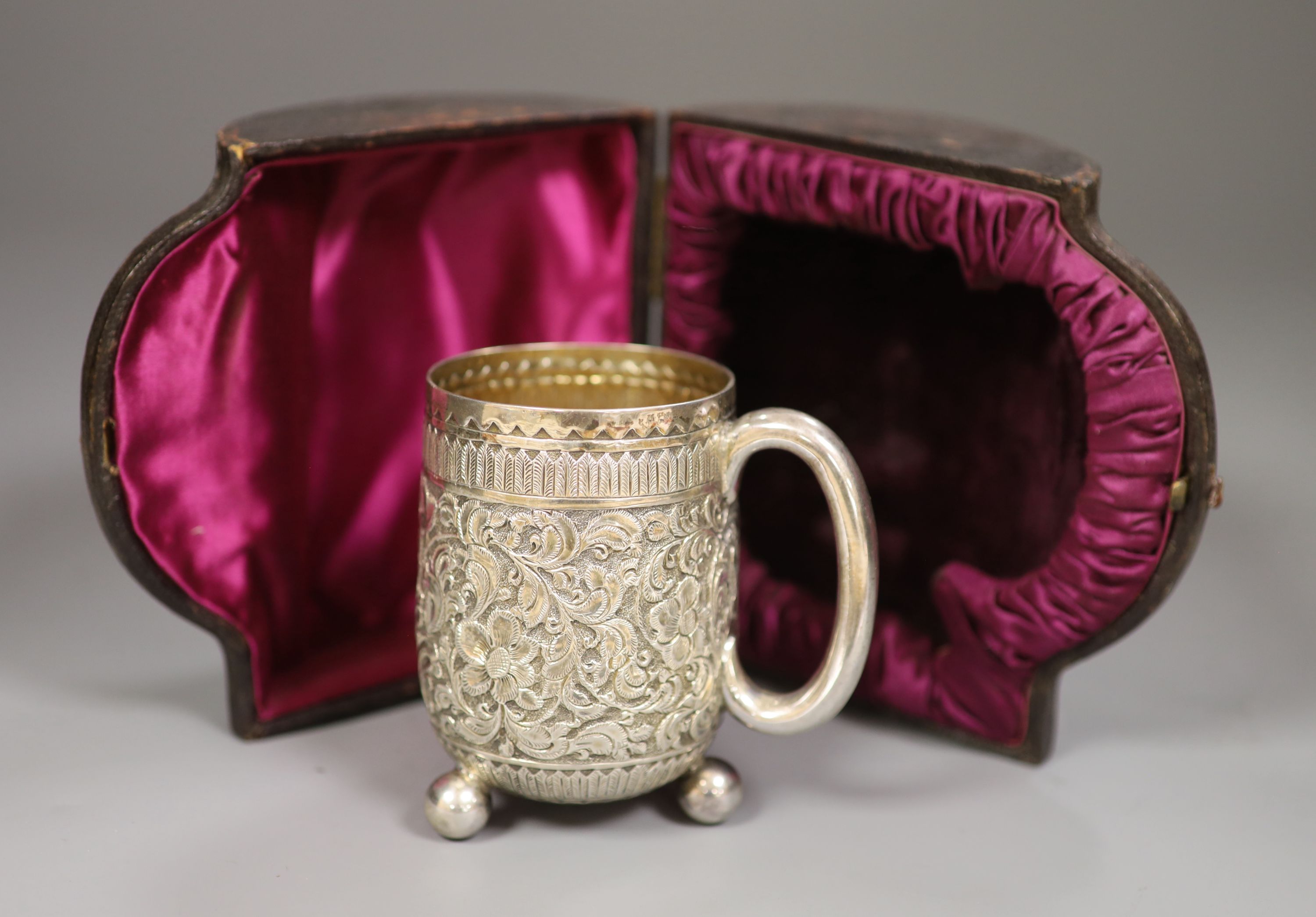 A cased Victorian embossed silver christening cup, Charles Boyton II, London, 1887, 93mm, 4oz.